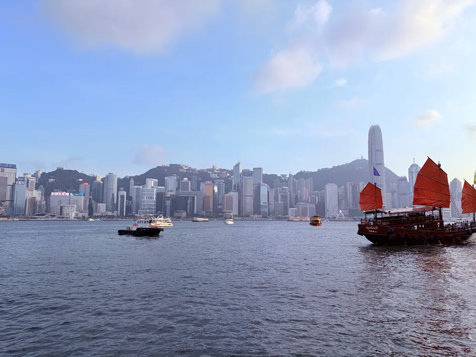 蓝天下的维港城市与红帆船